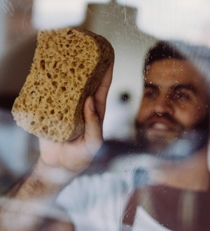 Huishoudhulp Germani maakt de ramen proper in de woonkamer